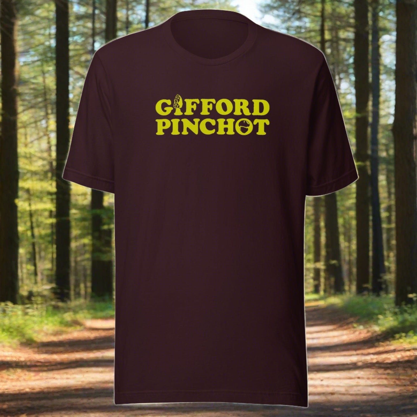 a short sleeve t-shirt featuring the phrase Gifford Pinchot in goldenrod. There is a morel mushroom where the letter I should be in the word Gifford and a porcini where the O should be in Pinchot.